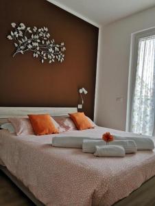 una camera da letto con un letto grande con cuscini arancioni e bianchi di My Home a Lazise