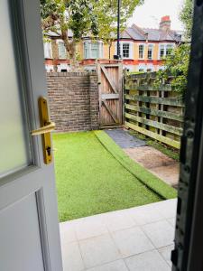 ロンドンにあるOmegaの門と芝生のある庭に通じるドア