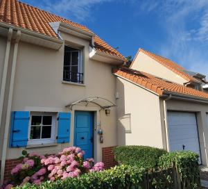 una casa con una porta blu e fiori di La Brise Bleue - Maison avec Jardin, Garage, 400m Plage a Bray-Dunes
