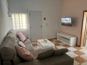 un salon avec un canapé et une table dans l'établissement Casa María Oliva 50m playa, à El Palmar