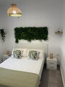 une chambre avec un lit blanc avec un mur vert dans l'établissement Casa María Oliva 50m playa, à El Palmar 23 autres photos