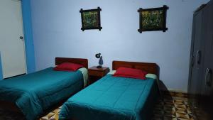 卡哈马卡Casa El Capulí的一间蓝色墙壁的房间里有两张床