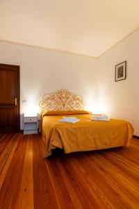 Un dormitorio con una cama con una colcha amarilla. en Bed & Breakfast - Ca' Broni, en Domodossola