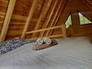 un lit dans une cabane avec deux peluches dessus dans l'établissement Wolf Apex, à Žabljak