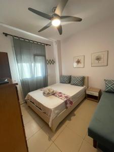 ein Schlafzimmer mit Bett und Deckenventilator in der Unterkunft Anastelia Apartments - 2 in Olympiada