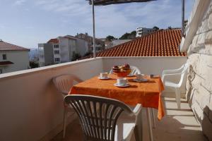 a table with a bowl of fruit on a balcony at Apartments Jure with Sea View in Dugi Rat