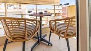 two chairs and a table on a balcony at Creticum Suites in Heraklio
