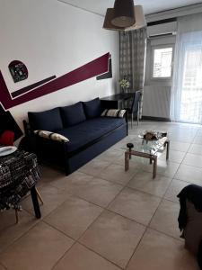 a living room with a blue couch and a table at Central Stylish Apartment in Thessaloniki