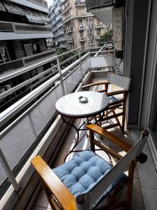 a balcony with two chairs and a table on a building at Central Stylish Apartment in Thessaloniki +17 photos