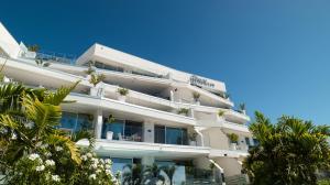 biały budynek z palmami przed nim w obiekcie Grand Horizon Luxury Boutique Apartments w mieście Puerto Rico de Gran Canaria +37 zdjęć