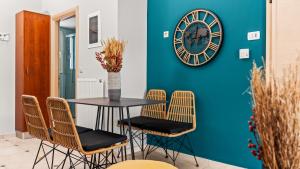 a table with chairs and a clock on a wall at Creticum Suites in Heraklio