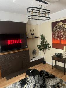 a living room with a television on a wall at Prettide Suite Two-1 free Parking in Gillingham