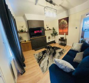 a living room with a blue couch and a tv at Prettide Suite Two-1 free Parking in Gillingham