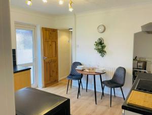 a kitchen with a table and chairs in a room at Prettide Suite Two-1 free Parking in Gillingham