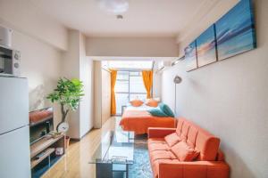 a living room with a couch and a bed in it at 横須賀ビーチコテージハウス204 in Kusugaurachō