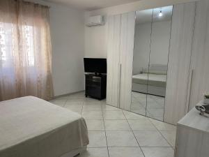 a bedroom with a bed and a tv and a mirror at Flora House in Brindisi