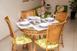 a dining room table with wicker chairs and a table and chairsktop at Flat Golden Beach Pitangueiras com Vista Mar in Guarujá