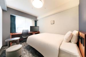 a hotel room with a bed and a desk at Richmond Hotel Yokohama-Bashamichi in Yokohama