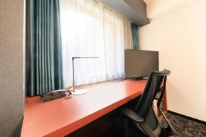 a desk with a computer on it with a window at Richmond Hotel Yokohama-Bashamichi in Yokohama