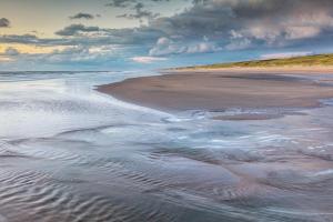 una vista de una playa con la marea entrando en DUINUNDER In de duinen, loopafstand naar 't strand, en Noordwijk aan Zee 4 fotos más
