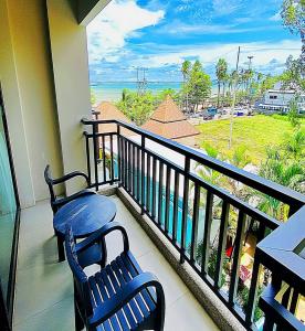 a balcony with two chairs and a view of the ocean at Royal Thai Pavilion Jomtien Hotel in Jomtien Beach