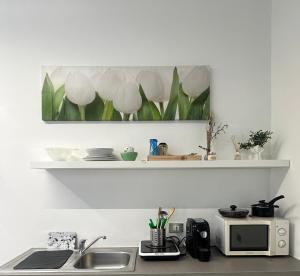 un bancone da cucina con un lavandino e un forno a microonde di Vigevano Studios a Vigevano