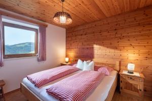 a bedroom with a bed and a wooden wall at Ferienhaus Soregina in Ellmau