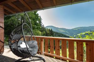 a rocking chair on a porch with a view of mountains at Ferienhaus Soregina in Ellmau