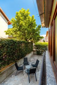 un patio con sillas, una mesa y un seto en Bed & Breakfast - Ca' Broni, en Domodossola