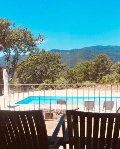 a beach with two chairs and a swimming pool at Gerês - Casa da Cabana in Vieira do Minho