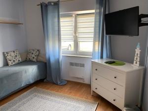 una piccola camera da letto con divano e finestra di Nasze Morze a Dziwnów