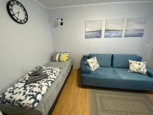 un soggiorno con divano blu e orologio di Nasze Morze a Dziwnów
