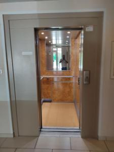 a glass door with a person standing in the mirror at studio du parc piscine in Souillac