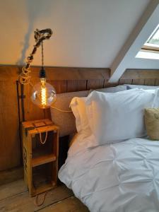 a lamp on a table next to a bed at Quaint Studio Loft Room nr Hampton Court in Thames Ditton