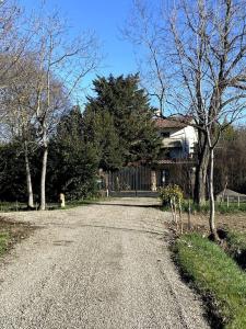 un camino de grava frente a una casa con árboles en Appartamento Bosco in Città, en Cadè
