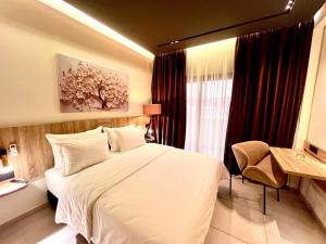 塔扎Hôtel Le Manoir的卧室里有一张白色的大床和一扇窗户