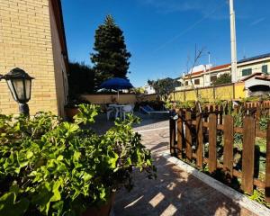 un jardín con una valla de madera y algunas plantas en Romano House, en Fiumicino