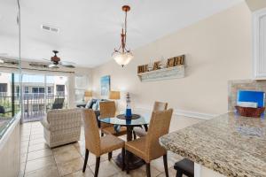 a kitchen and dining room with a table and chairs at Poolside Villas #302- Harry's Beach House in Destin