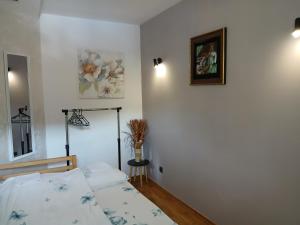 ein Schlafzimmer mit einem Bett und einem Bild an der Wand in der Unterkunft Apartman Jovanović in Vrnjačka Banja