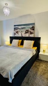 een slaapkamer met een groot bed met een schilderij aan de muur bij Elite Residence in Timişoara