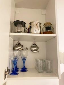 a shelf with glasses and pots and pans at AQUA Apartment in Belgrade