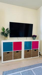 a flat screen tv on top of a white entertainment center at Elite Residence - Modern 2BR - Sleeps 6 - FREE Parking in Timişoara
