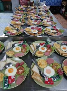 une table pleine d'assiettes de nourriture avec des œufs dessus dans l'établissement Khao Sok River Canoe&Resort, à Khao Sok