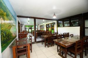 a restaurant with tables and chairs and a painting on the wall at Hotel Vale Verde in Porto Seguro
