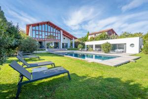 une cour arrière avec une piscine et une maison dans l'établissement Lafitenia Resort, à Saint-Jean-de-Luz