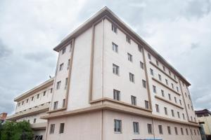 a large white building with a triangular top at Dunia Hôtel Bamako ACI 2000 in Bamako