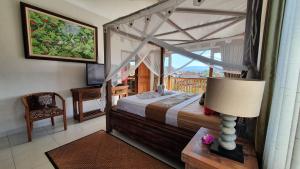 Un dormitorio con una cama y una mesa con una lámpara. en Villa Santai Karangasem, en Tirtagangga