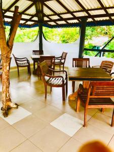 grupa drewnianych stołów i krzeseł w pawilonie w obiekcie Castle Bay Resort w mieście Weligama