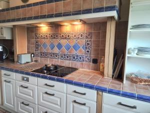 a kitchen with a stove and a tiled wall at Mein Wunschhaus in Rodgau