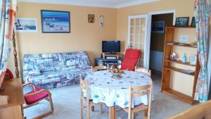 a living room with a table and a couch at Appartement Schaffhauser in Les Sables-d'Olonne